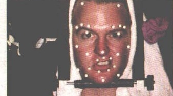 Behind-the-scenes photo — facial motion-capture markers on an actor's face