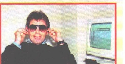 Ascultătorul cu ochelari de soare, la căști, lângă un PC