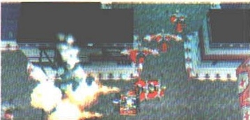 Captură: explozie lângă o structură metalică, cu androizi roșii pe pasarelă (fără text de legendă tipărit)
