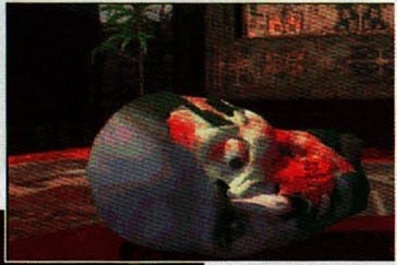 Screenshotul din mijlocul paginii: un cadavru însângerat întins pe covorul unei camere cu plante. Nu poartă nicio legendă tipărită